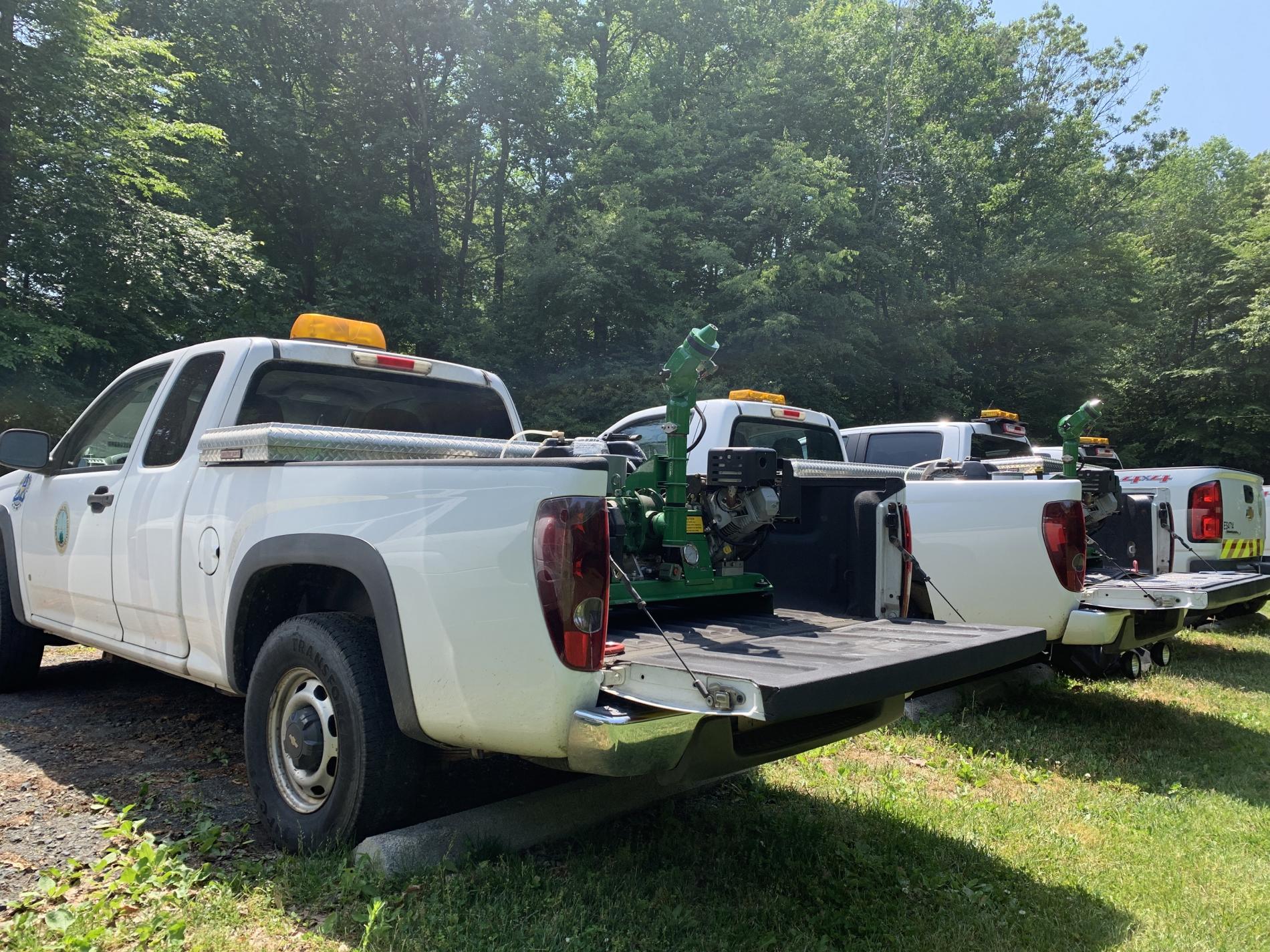 White Work Trucks with green mosquito adulticide machines