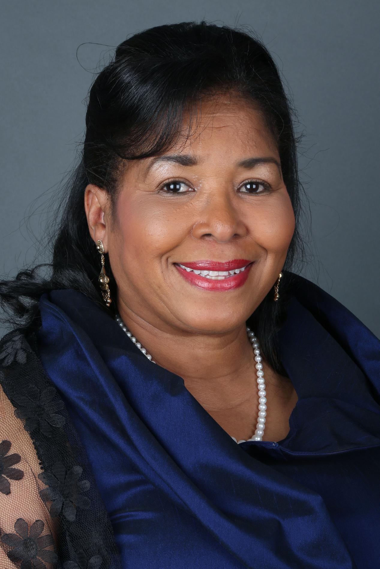 Headshot of an African American woman, facing forward, in a black top
