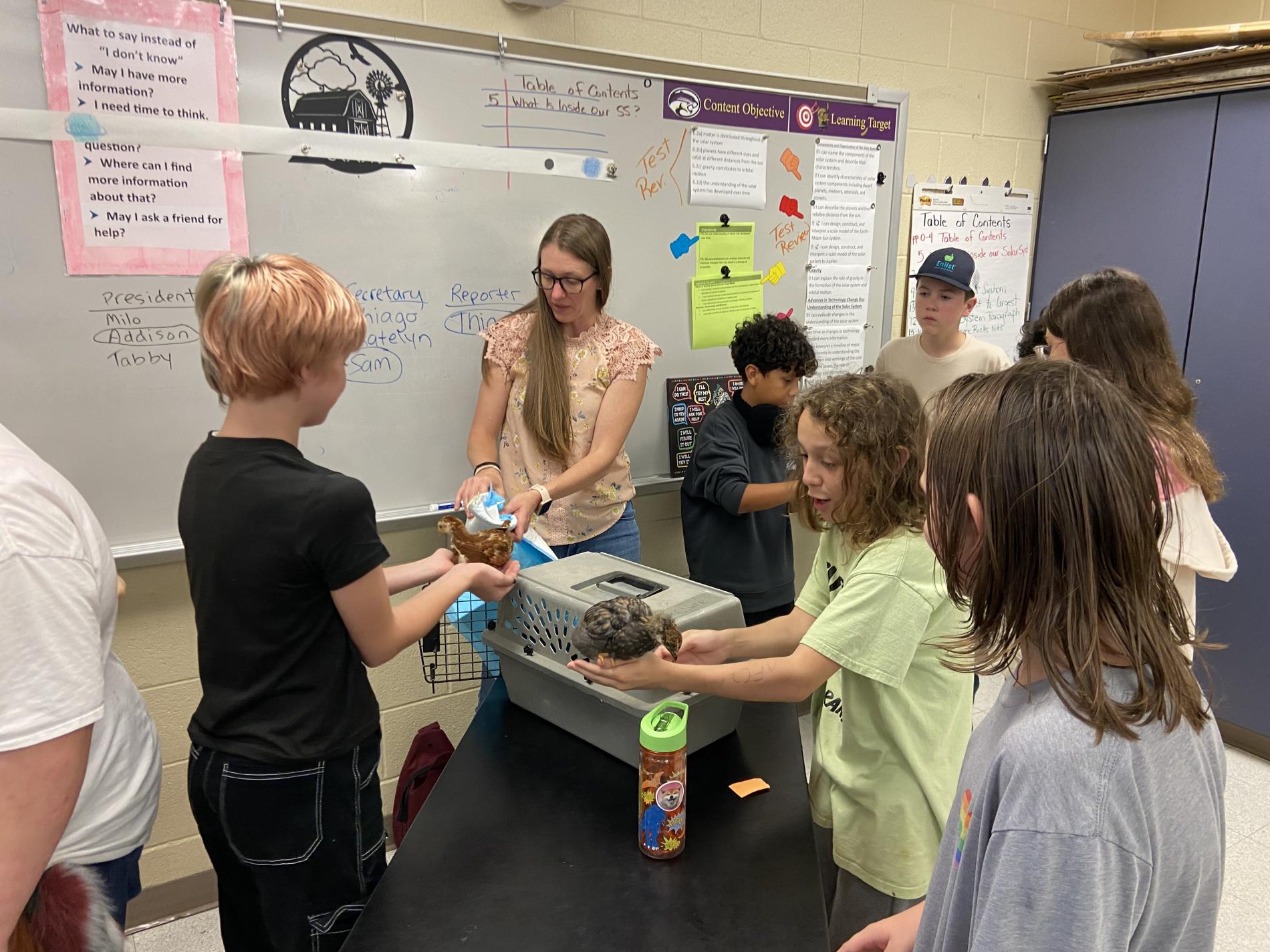 4-H'ers in a classroom holding ducks.