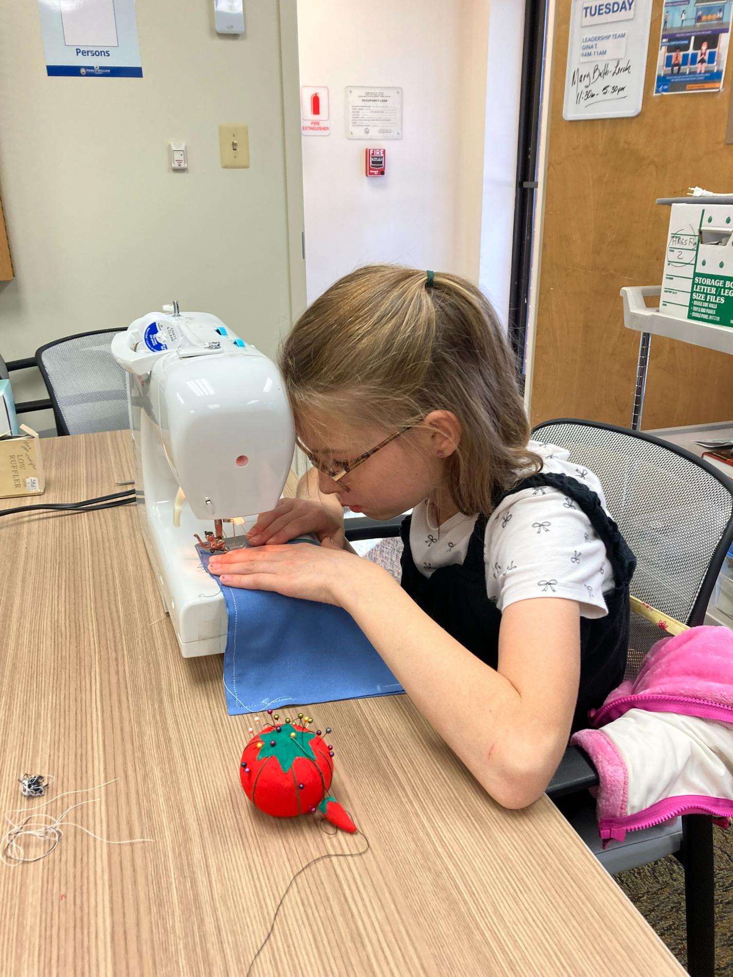 Prince William 4-H'er learning sewing skills by stitching a book bag.