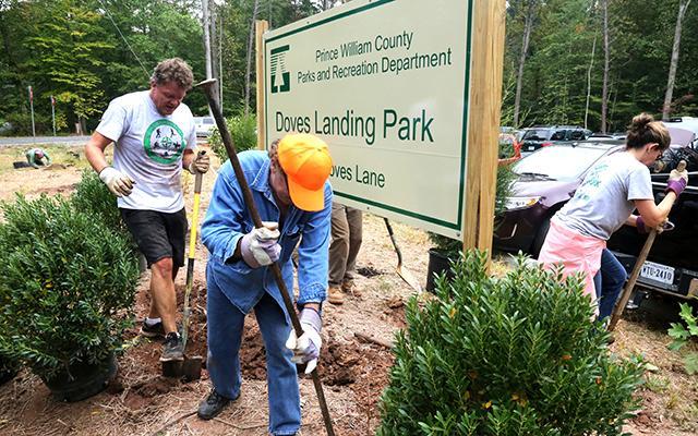 Three people digging dirt for a Park